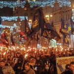 Personas con antorchas y banderas nacionalistas del partido político ultranacionalista de extrema derecha Svoboda durante un mitin de varios partidos nacionalistas para conmemorar el 112 cumpleaños de Stepan Bandera, en Kiev, Ucrania, en enero de 2021