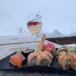 Una copa de Moët Chandon Ice Impèrial, con vistas a la nieve, y el surtido de shushis, maki roll y nigiris