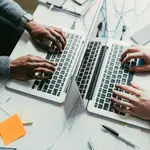 Dos personas trabajan con ordenadores