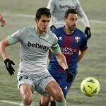 El defensa de la SD Huesca Pedro López (d) lucha con el argelino Aissa Mandi, del Real Betis, durante el partido de la jornada 18 de Liga en Primera División que se juega hoy lunes en El Alcoraz, en Huesca. EFE/JAVIER BLASCO