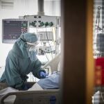 Un trabajador sanitario atiende a un paciente en una camilla de la UCI de la Clínica Universidad de Navarra, en Pamplona, Navarra, (España), a 10 de noviembre de 2020.