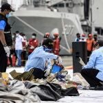 FILED - 10 January 2021, Indonesia, Jakarta: National Transportation Safety Committee and Disaster Victim Identification (DVI) police officers look through a bag of suspected debris near the crash site of the Sriwijaya Air flight SJ182 at Tanjung Priok port following the crash of a Boeing 737-500 passenger plane with 62 people on board. Photo: Risa Krisadhi/SOPA Images via ZUMA Wire/dpaRisa Krisadhi/SOPA Images via ZU / DPA10/01/2021 ONLY FOR USE IN SPAIN