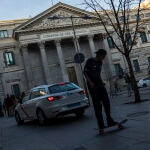 Transeúntes pasan frente a la Fachada del Congreso de los Diputados.
