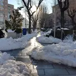 Calle del barrio de Moratalaz (Madrid), con un pasillo entre la nieve, una semana después de la nevada que trajo el temporal Filomena.