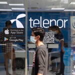 Un hombre pasa junto a un centro de Telenor en Yangon