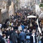Centos de personas caminan por una abarrotada calle del centro de Roma (Italia)