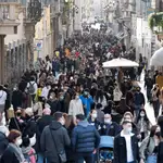 Centos de personas caminan por una abarrotada calle del centro de Roma (Italia)