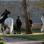 Una patrulla de Policia Nacional a caballo, controla que se cumplan el uso de las mascarillas en el antiguo cauce del río Turia, en Valencia