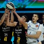 El ala-pívot estadounidense Tyler Cavanaugh (i) y el pívot georgiano Giorgi Shermadini (c), de Lenovo Tenerife, pelean un rebote ante el pívot serbio con pasaporte canadiense Dejan Kravic (d), del San Pablo Burgos, durante el encuentro de cuartos de final de la Copa del Rey entre Lenovo Tenerife y San Pablo Burgos, este jueves en el WiZink Center de Madrid. EFE/ Juan Carlos Hidalgo