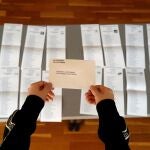 Una persona coge un sobre para las elecciones al Parlamento de Cataluña 2021