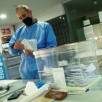 Un miembro de la mesa electoral de El Masnou (Cataluña), con el EPI, hace el recuento de votos para las elecciones al Parlament de Catalunya