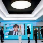 El expresidente Carles Puigdemont participa por videoconferencia en la rueda de prensa que ofrecen los miembros de JxCat
