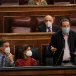 El vicepresidente segundo del Gobierno, Pablo Iglesias (d), habla en presencia del presidente del Gobierno, Pedro Sánchez (i), y la vicepresidenta primera, Carmen Calvo (c)