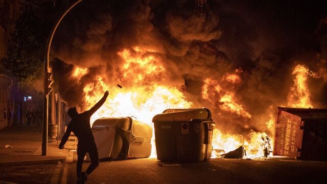 Un manifestante lanza objetos contra la polic&iacute;a durante los disturbios en Barcelona