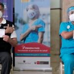 El presidente de Perú, Francisco Sagasti, y una enfermera muestran los documentos que certifican su vacunación
