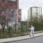 Una persona desinfecta el perímetro que rodea el colegio público CEIP Paradai, en Lugo, Galicia (España)