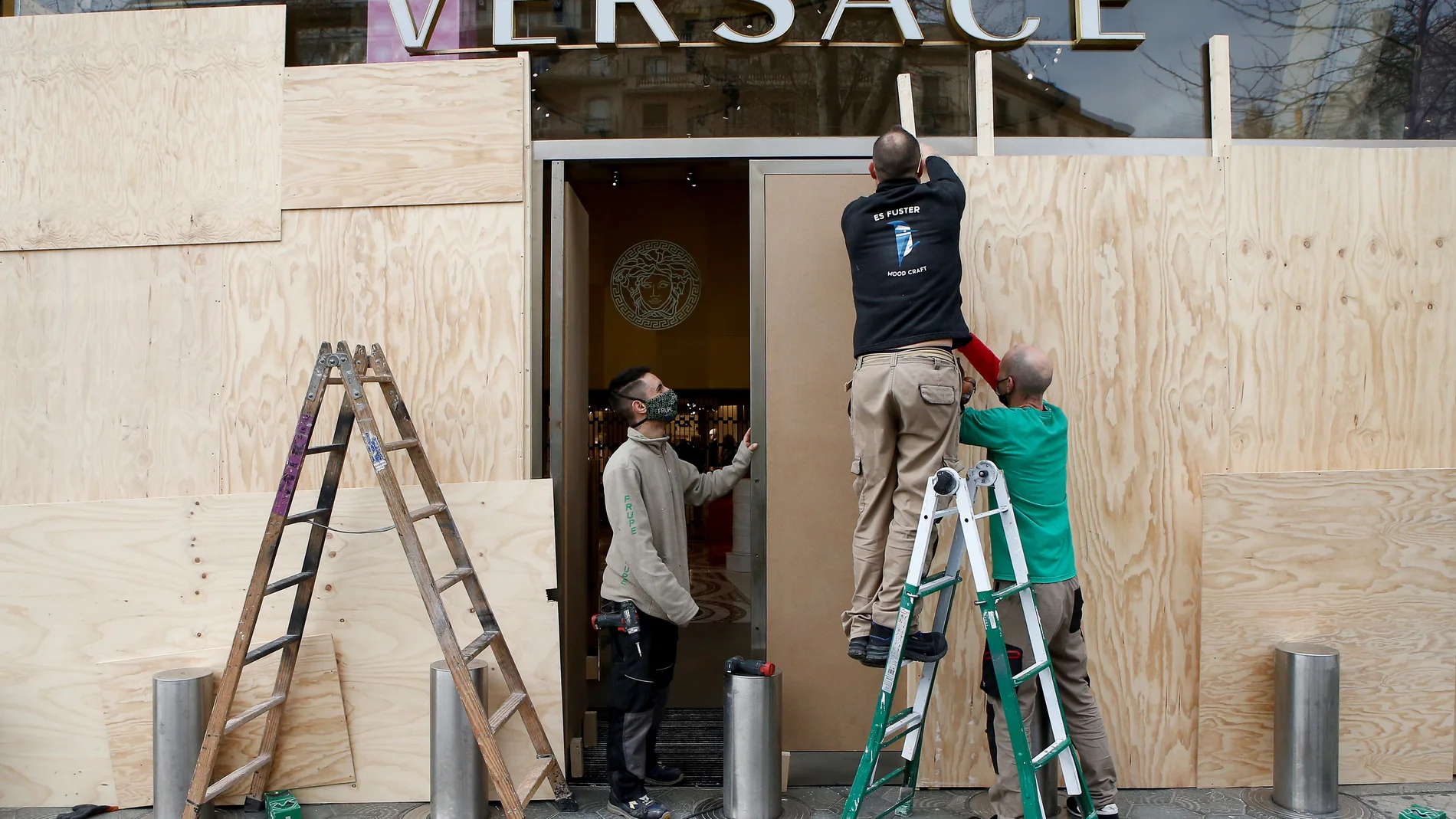 Varios operarios arreglan los desperfectos del paseo de Gràcia de Barcelona después de que los Mossos d'Esquadra hayan detenido esta pasada noche a un total de 38 personas en Cataluña