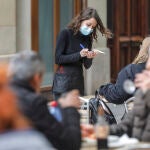 Una camarera atiende a varios clientes en una terraza en Valencia