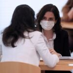 La presidenta de la Comunidad de Madrid, Isabel Díaz Ayuso (d) conversa con la portavoz de Vox en la Asamblea, Rocío Monasterio