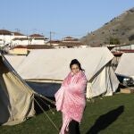 Una niña junto a una tienda de campaña usa una manta para mantenerse abrigada después de un terremoto en la aldea de Damasi, en el centro de Grecia