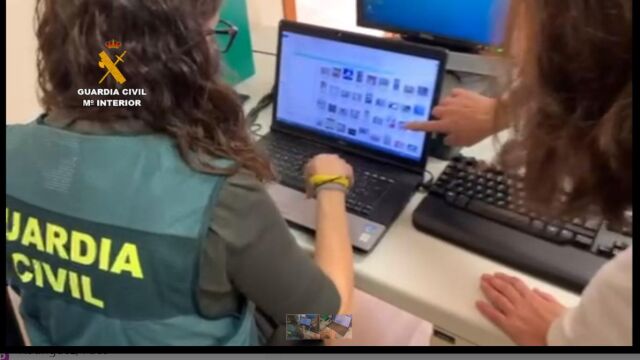 Agentes examinan las imágenes que se incautaron al arretado