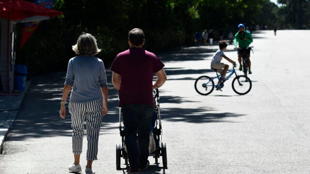Una pareja con un carrito de bebé en un parque