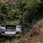 Los residentes inspeccionan los restos de un autobús que se cayó por un barranco en Java Occidental