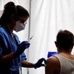 Una profesional sanitaria administra la vacuna contra la COVID-19 a un ciudadano en los pasillos del Hotel SB Plaza Europa, ubicado cerca del recinto de Fira de Barcelona de L'Hospitalet de Llobregat (Barcelona)