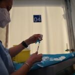 Una profesional sanitaria sostiene una jeringuilla y un vial con la vacuna contra la Covid-19 de AstraZeneca en el Hospital de campaña de La Fe, en Valencia.