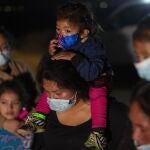 Familias migrantes de Guatemala esperan a una patrulla fronteriza de EE UU después de haber cruzado el Río Grande en una balsa inflable