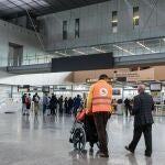 Una persona con discapacidad es ayudada a desplazarse en un aeropuerto en una silla de ruedas