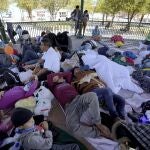 A group of migrants rest on a gazebo at a park after the deportees from the U.S. were pushed by Mexican authorities off an area they had been staying after their expulsion, Saturday, March 20, 2021, in Reynosa, Mexico. The Biden administration says that it's working to address the increase in migrants coming to the border. (AP Photo/Julio Cortez)