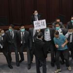 FILE - In this Monday, May 18, 2020, file photo, pro-democracy lawmaker Wu Chi-wai, right in polo shirt, scuffles with security guards during a Legislative Council's House Committee meeting in Hong Kong. China's top legislature approved amendments to Hong Kong's constitution on Tuesday, March 30, 2021, that will give Beijing more control over the make-up of the city's legislature.Â  (AP Photo/Vincent Yu, File)