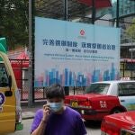 Un hombre pasa junto a un anuncio del gobierno que promueve las reformas electorales de Hong Kong