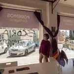 La portavoz de Podemos en sede de Podemos en Cartagena Leli García junto a las pintadas en la sede del partido en Cartagena