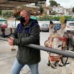 Uno de los arrieros del burro taxi de Mijas (Málaga), Salvador Torres, a quienes la falta de turistas a causa de las restricciones de movilidad para frenar la pandemia ha puesto ante una de las temporadas más duras que recuerdan. EFE/Esther Gómez