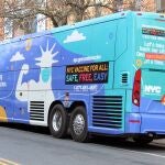 Autobús decorado con un dibujo de la estatua de la Libertad con tapabocas y una tirita en el brazo como señal de que se ha vacunado, uno de los dos autobuses convertidos en unidad móvil para vacunar contra la covid-19, estacionados en Brooklyn, Nueva York (EE.UU)