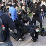 Radicales patean a un policía nacional en el suelo y sin casco 