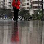 - Una persona se protege con un paraguas de la lluvias
