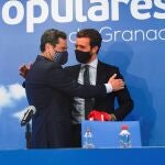 El líder del PP, Pablo Casado, a la derecha, abraza al presidente del PP-A y de la Junta de Andalucía, Juanma Moreno, durante la clausura del consejo provincial de alcaldes y portavoces del PP de Granada