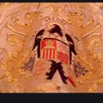 El escudo con el Águila de San Juan, en el manto de la Virgen