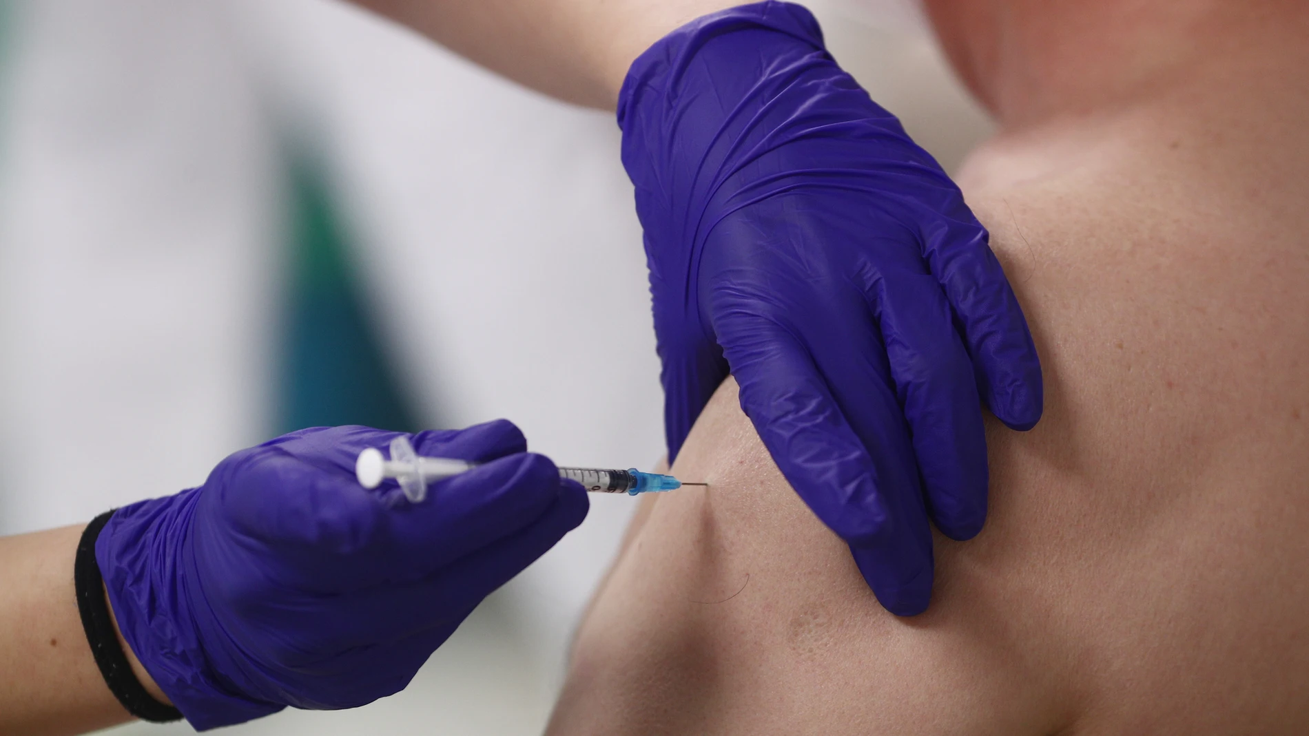 Una sanitaria inocula la primera dosis de la vacuna Pzifer a un anciano, en el Hospital Universitario de La Paz de Madrid