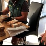 Un agente cuenta el dinero que se ha incautado en una de las operaciones