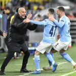 Foden y Walker celebran con Guardiola el segundo gol del Manchester City al Borussia Dortmund en los cuartos de la Champions