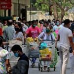People push trolleys loaded with grocery items as others wait to enter a supermarket, amidst the spread of the coronavirus disease (COVID-19) in Mumbai, India, April 14, 2021. REUTERS/Niharika Kulkarni