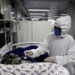 Una enfermera alimenta a un paciente contagiado por covid-19 hoy, en el Hospital General de Nova Iguaçú, en el área metropolitana de Río de Janeiro (Brasil