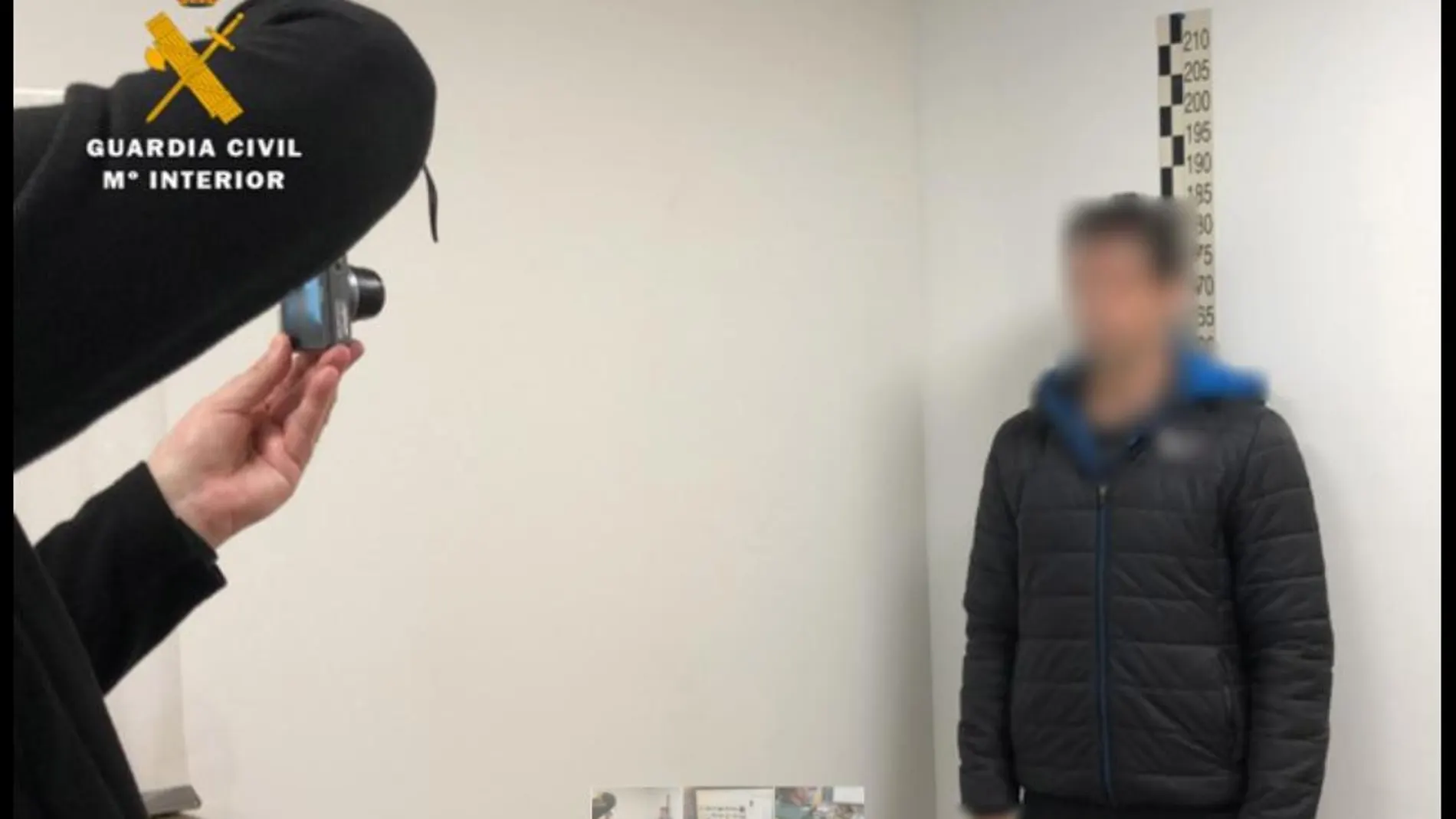 Un agente fotografía a uno de los arrestados en la operación