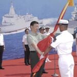 El presidente chino, Xi Jinping, presenta una bandera del Ejército Popular de Liberación (EPL) en la provincia de Hainan, sur de China