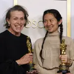 Frances McDormand (izq.) y Chloé Zhao posan con dos de los tres Oscar que ha ganado "Nomadland", la gran triunfadora de la noche.