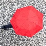 Una persona se protege de la lluvia en Zaragoza.